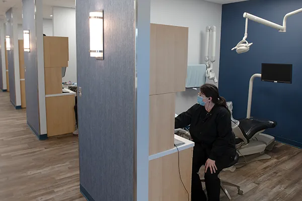 A dental assistant working on a computer in an operatory at Town Center Dental.